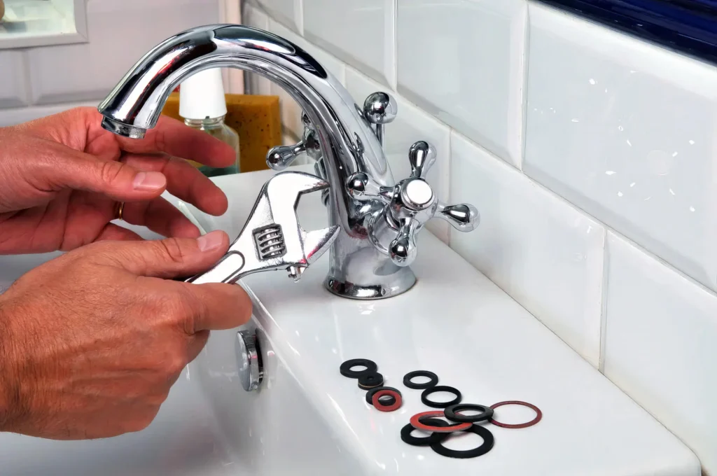 Plumber performing maintenance on a bathroom faucet in Denver