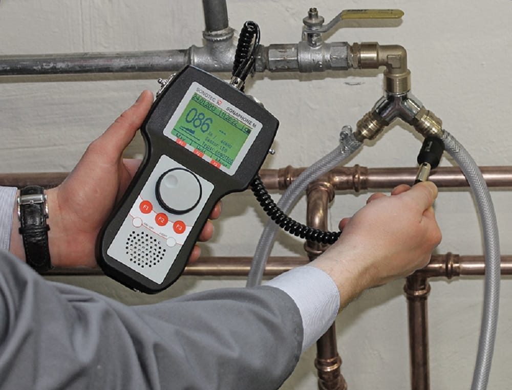 Plumber testing pipes with electronic leak detection equipment in Denver