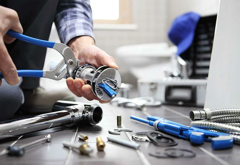 Technician repairing a plumbing fixture with professional tools in Denver