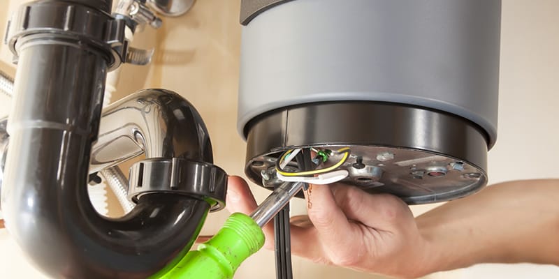 Technician repairing the heating element of a water heater in Denver
