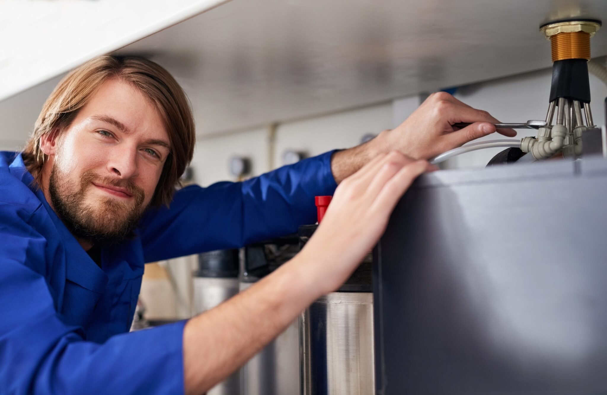 Technician servicing a residential water heater tank in Denver